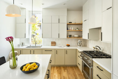 Example of a mid-sized transitional l-shaped medium tone wood floor kitchen pantry design in San Francisco with an undermount sink, recessed-panel cabinets, white cabinets, quartz countertops, gray backsplash, ceramic backsplash, stainless steel appliances, an island and white countertops