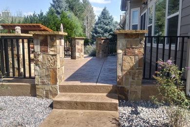Large country backyard full sun garden in Denver with with fireplace and natural stone pavers.