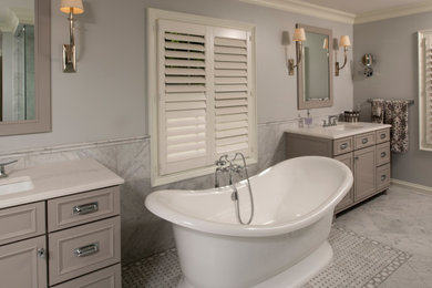 Inspiration for a large transitional master bathroom in Detroit with furniture-like cabinets, grey cabinets, a freestanding tub, an open shower, a two-piece toilet, gray tile, stone tile, grey walls, marble floors, an undermount sink, engineered quartz benchtops, grey floor, an open shower and white benchtops.