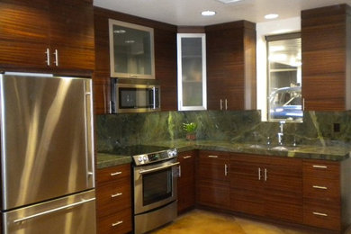 Small trendy u-shaped concrete floor enclosed kitchen photo in San Diego with a double-bowl sink, flat-panel cabinets, medium tone wood cabinets, granite countertops, stone slab backsplash, stainless steel appliances and no island