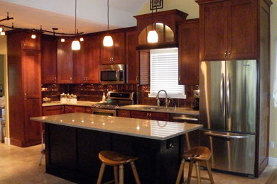 Example of a mid-sized classic l-shaped ceramic tile eat-in kitchen design with an undermount sink, shaker cabinets, dark wood cabinets, granite countertops, metallic backsplash, stainless steel appliances and an island