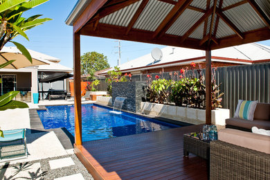 Design ideas for an expansive tropical backyard deck in Perth with a pergola.