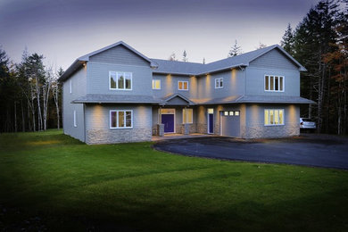 Example of a huge minimalist gray two-story mixed siding gable roof design in Other