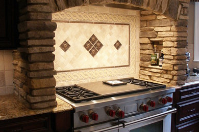 Example of a large u-shaped ceramic tile eat-in kitchen design in Little Rock with an undermount sink, raised-panel cabinets, dark wood cabinets, granite countertops, beige backsplash, stainless steel appliances and a peninsula