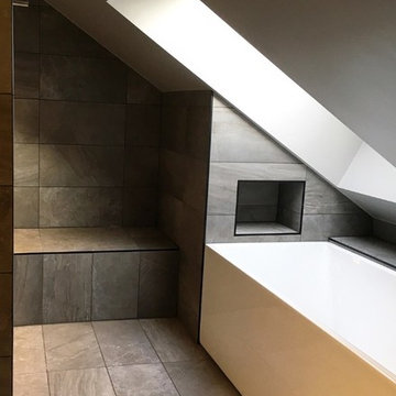 Badrum med walk-in shower, ångbad, snedtak och djupt takfönster.