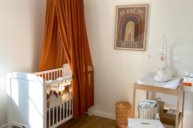Cette photo montre une chambre de bébé fille nature de taille moyenne avec un mur blanc, parquet clair, un sol marron et un plafond en bois.