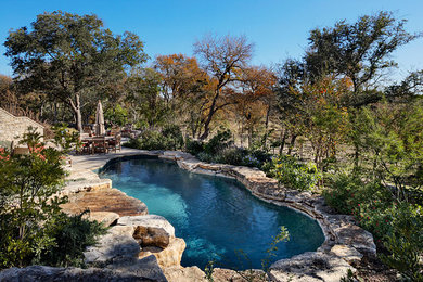 Example of a mid-sized mountain style backyard custom-shaped natural pool design in Austin