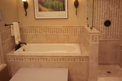 Example of a small master beige tile and ceramic tile corner shower design in Louisville with an undermount tub