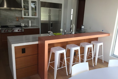 Mid-sized minimalist galley light wood floor and beige floor eat-in kitchen photo in Phoenix with an undermount sink, flat-panel cabinets, white cabinets, quartzite countertops, multicolored backsplash, stone slab backsplash, stainless steel appliances and a peninsula