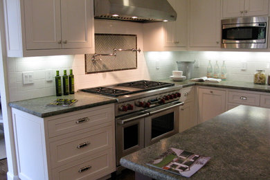 Mid-sized elegant l-shaped dark wood floor and brown floor enclosed kitchen photo in San Francisco with an undermount sink, shaker cabinets, white cabinets, granite countertops, white backsplash, subway tile backsplash, stainless steel appliances and an island