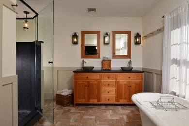Inspiration for a large craftsman master porcelain tile porcelain tile bathroom remodel with shaker cabinets, medium tone wood cabinets, a vessel sink and black countertops