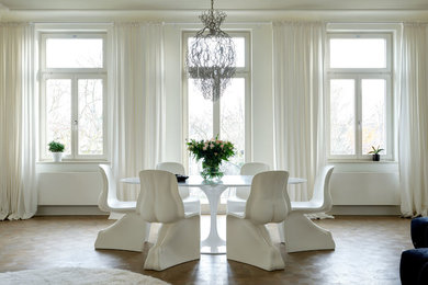 Inspiration for a mid-sized contemporary separate dining room in Berlin with white walls, medium hardwood floors, no fireplace and beige floor.