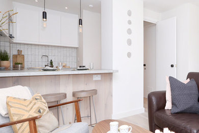 Small contemporary open plan living room in London with grey walls and light hardwood flooring.