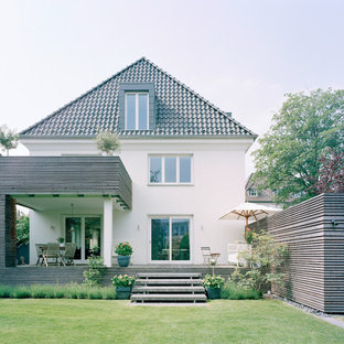 Exempel på ett mellanstort modernt vitt hus, med tre eller fler plan och valmat tak