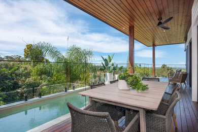 Photo of a mid-sized modern balcony in Sunshine Coast with glass railing.