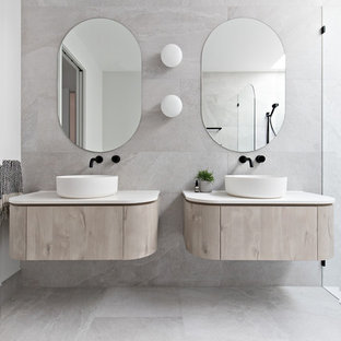 Idee per una stanza da bagno minimalista con ante lisce, ante in legno chiaro, piastrelle beige, pareti bianche, lavabo a bacinella, pavimento beige e top bianco