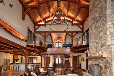 Photo of a country open concept living room in Other with white walls, medium hardwood floors, a standard fireplace, a stone fireplace surround and brown floor.