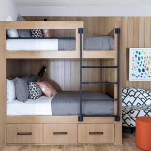 Esempio di una grande cameretta per bambini chic con pareti marroni, parquet chiaro, pavimento marrone e pareti in legno