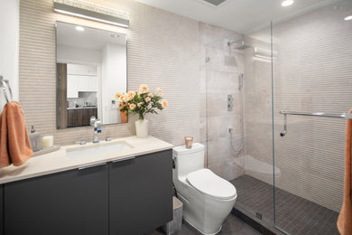 Mid-sized trendy gray tile and porcelain tile porcelain tile, brown floor and single-sink doorless shower photo in San Diego with flat-panel cabinets, gray cabinets, a one-piece toilet, white walls, an undermount sink, quartzite countertops, a hinged shower door, white countertops, a niche and a floating vanity