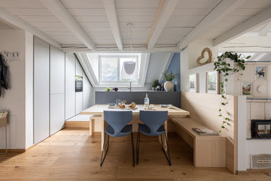 Foto di una sala da pranzo nordica con pareti bianche, parquet scuro, stufa a legna, pavimento marrone e travi a vista