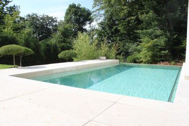Mittelgroßer Mediterraner Infinity-Pool neben dem Haus mit Natursteinplatten in Frankfurt am Main