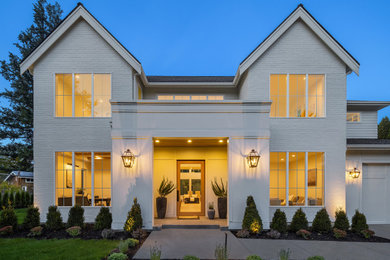 Large french country white two-story brick and clapboard exterior home photo in Seattle with a shingle roof and a gray roof
