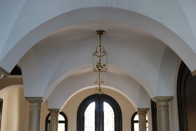 Inspiration for a mid-sized mediterranean limestone floor and beige floor entryway remodel in Tampa with white walls and a dark wood front door