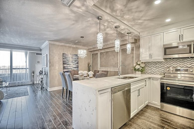 Open concept kitchen - mid-sized transitional u-shaped medium tone wood floor and brown floor open concept kitchen idea in Toronto with an undermount sink, recessed-panel cabinets, white cabinets, quartz countertops, gray backsplash, marble backsplash, stainless steel appliances and a peninsula