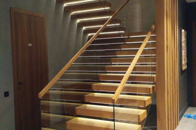 На фото: угловая лестница с деревянными ступенями и деревянными перилами с