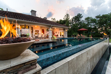 Large transitional backyard stone and rectangular pool photo in Houston