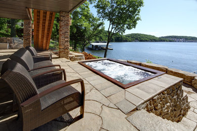 Example of a large arts and crafts backyard concrete paver patio design in Other with a fire pit and a roof extension
