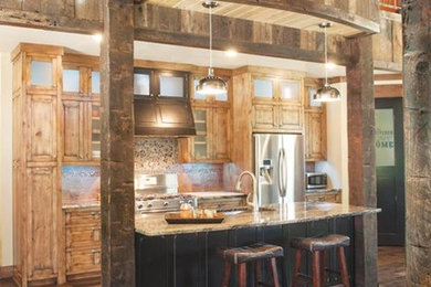 Kitchen - rustic kitchen idea in Other with an undermount sink, raised-panel cabinets, distressed cabinets, granite countertops, gray backsplash, stainless steel appliances and an island