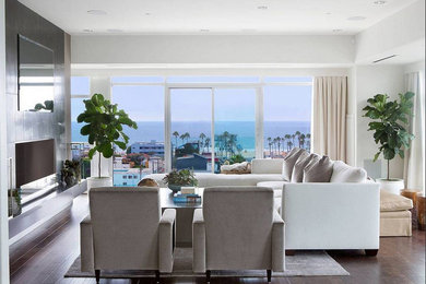 Example of a large trendy open concept dark wood floor living room design in Los Angeles with white walls and a concealed tv