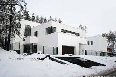 Modelo de fachada de casa blanca contemporánea de tamaño medio de dos plantas con tejado plano