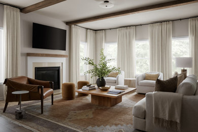 Example of a mid-sized transitional open concept medium tone wood floor, brown floor and exposed beam living room design in DC Metro with beige walls, a standard fireplace, a stone fireplace and a wall-mounted tv