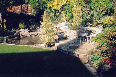 ロンドンにある高級な小さな、夏のラスティックスタイルのおしゃれな裏庭 (池、半日向、天然石敷き) の写真