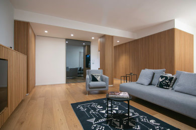 Small contemporary open plan living room in Other with medium hardwood flooring, a built-in media unit, a drop ceiling and wood walls.