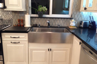 Eat-in kitchen - mid-sized transitional l-shaped porcelain tile and multicolored floor eat-in kitchen idea in Los Angeles with a farmhouse sink, raised-panel cabinets, white cabinets, quartz countertops, multicolored backsplash, ceramic backsplash, stainless steel appliances, an island and white countertops