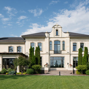 Удачное сочетание для дизайна помещения: трехэтажный фасад частного дома бежевого цвета в стиле современная классика с вальмовой крышей, комбинированной облицовкой и металлической крышей - самое интересное для вас