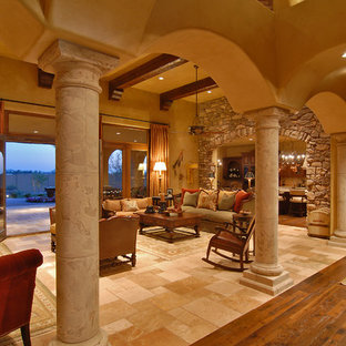 Modelo de salón abierto, mediterráneo, grande, con paredes beige, suelo de travertino y suelo beige