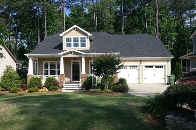 Mid-sized elegant beige two-story vinyl exterior home photo in Raleigh with a hip roof