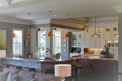 Large transitional l-shaped dark wood floor and brown floor seated home bar photo in Milwaukee with an undermount sink, shaker cabinets, white cabinets and marble countertops