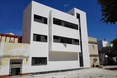 Modelo de fachada blanca moderna de tamaño medio de tres plantas con revestimientos combinados y tejado plano