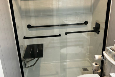 Example of a small minimalist vinyl floor, black floor, single-sink and wall paneling bathroom design in Dallas with shaker cabinets, white cabinets, a two-piece toilet, gray walls, an integrated sink, granite countertops, white countertops and a freestanding vanity