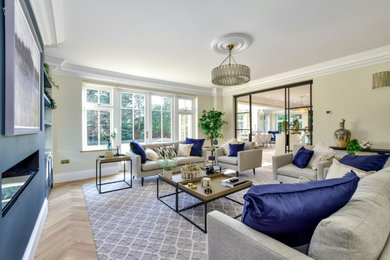 Design ideas for a classic enclosed living room in Hertfordshire with beige walls and light hardwood flooring.