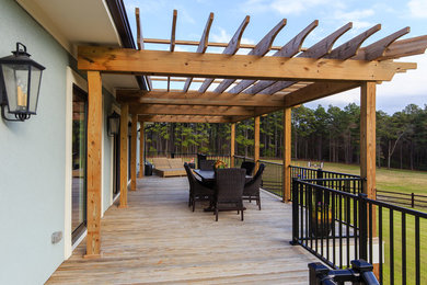 Large arts and crafts back porch photo in Raleigh with decking and a pergola