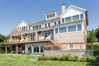 Inspiration for a large coastal brown three-story wood gable roof remodel in New York