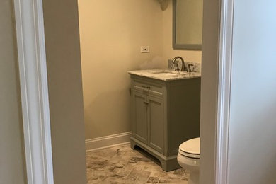 Alcove shower - mid-sized transitional 3/4 beige tile, brown tile and porcelain tile porcelain tile and beige floor alcove shower idea in Chicago with a two-piece toilet, an undermount sink, a hinged shower door, furniture-like cabinets, gray cabinets, beige walls and granite countertops