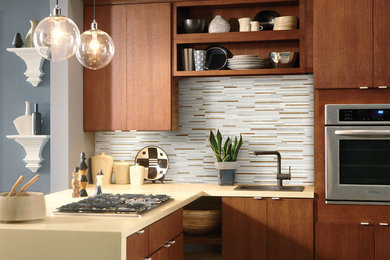 Example of a mid-sized trendy kitchen design in Orange County with a drop-in sink, flat-panel cabinets, dark wood cabinets, solid surface countertops, multicolored backsplash, matchstick tile backsplash and stainless steel appliances