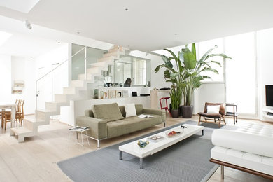 Inspiration for a large contemporary living room in Milan with white walls, light hardwood floors and a freestanding tv.